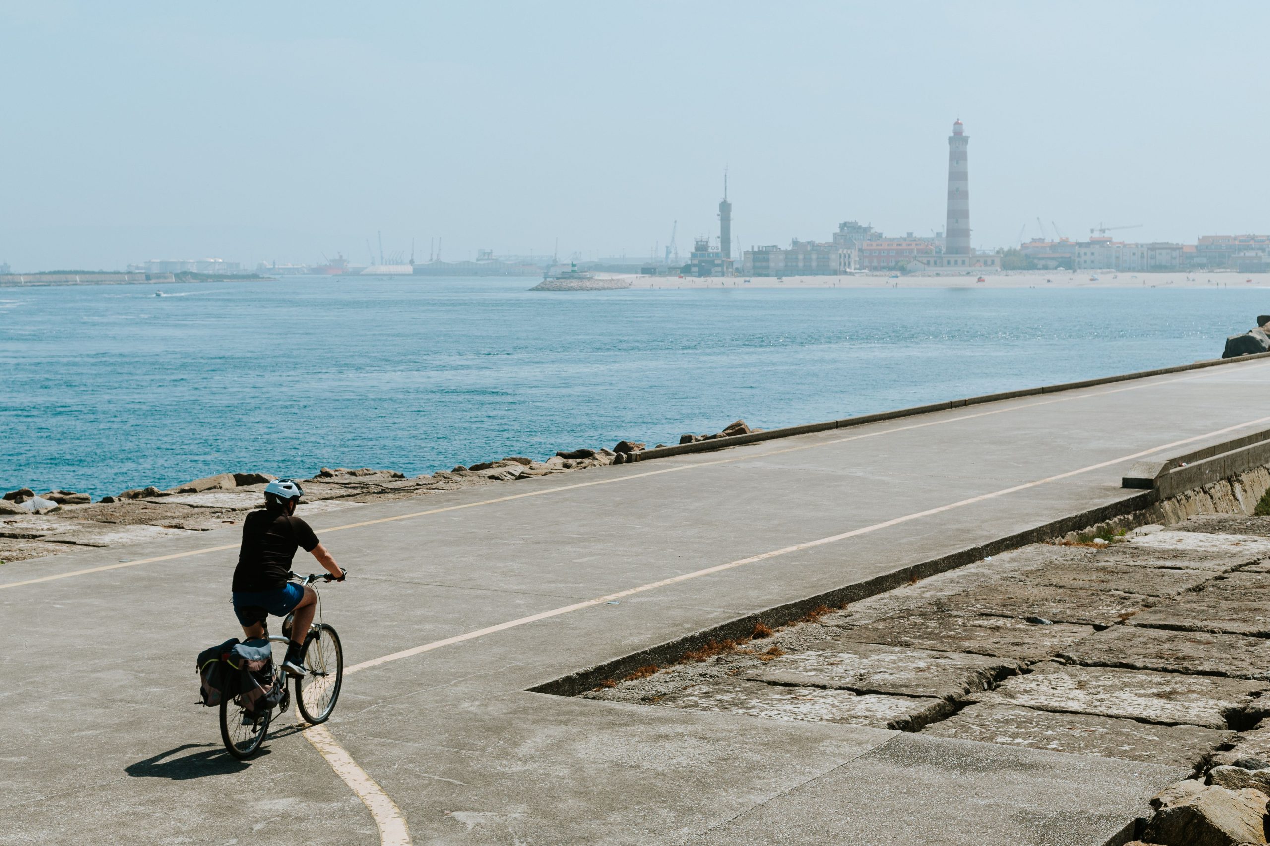 Cycliste sur sentier côtier avec phare