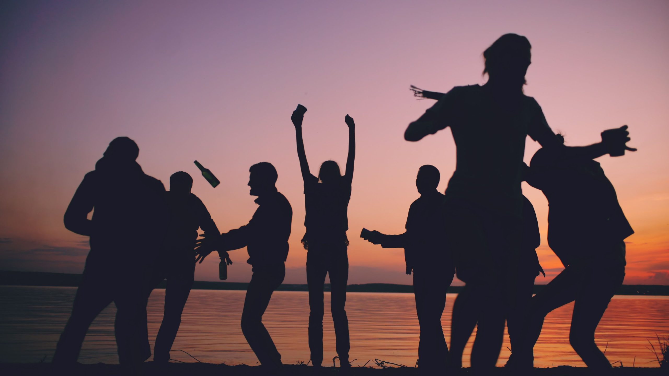 Amis profitant d'une fête de plage au coucher de soleil