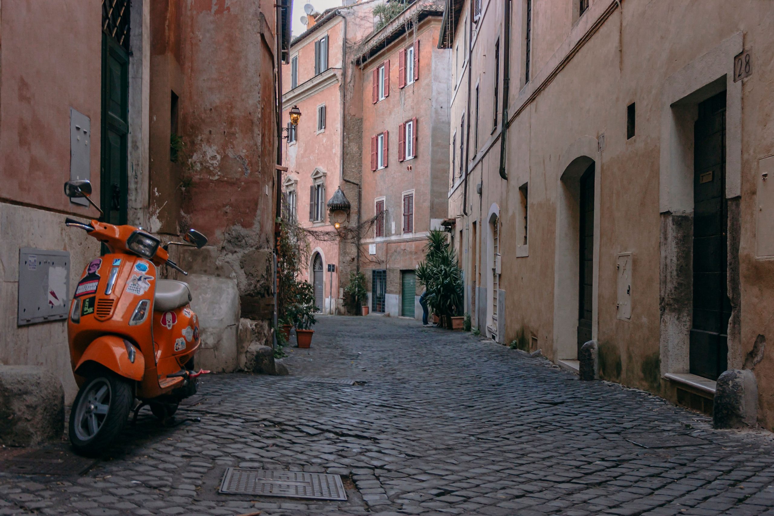 Scooter orange sur rue pavée à Trastevere