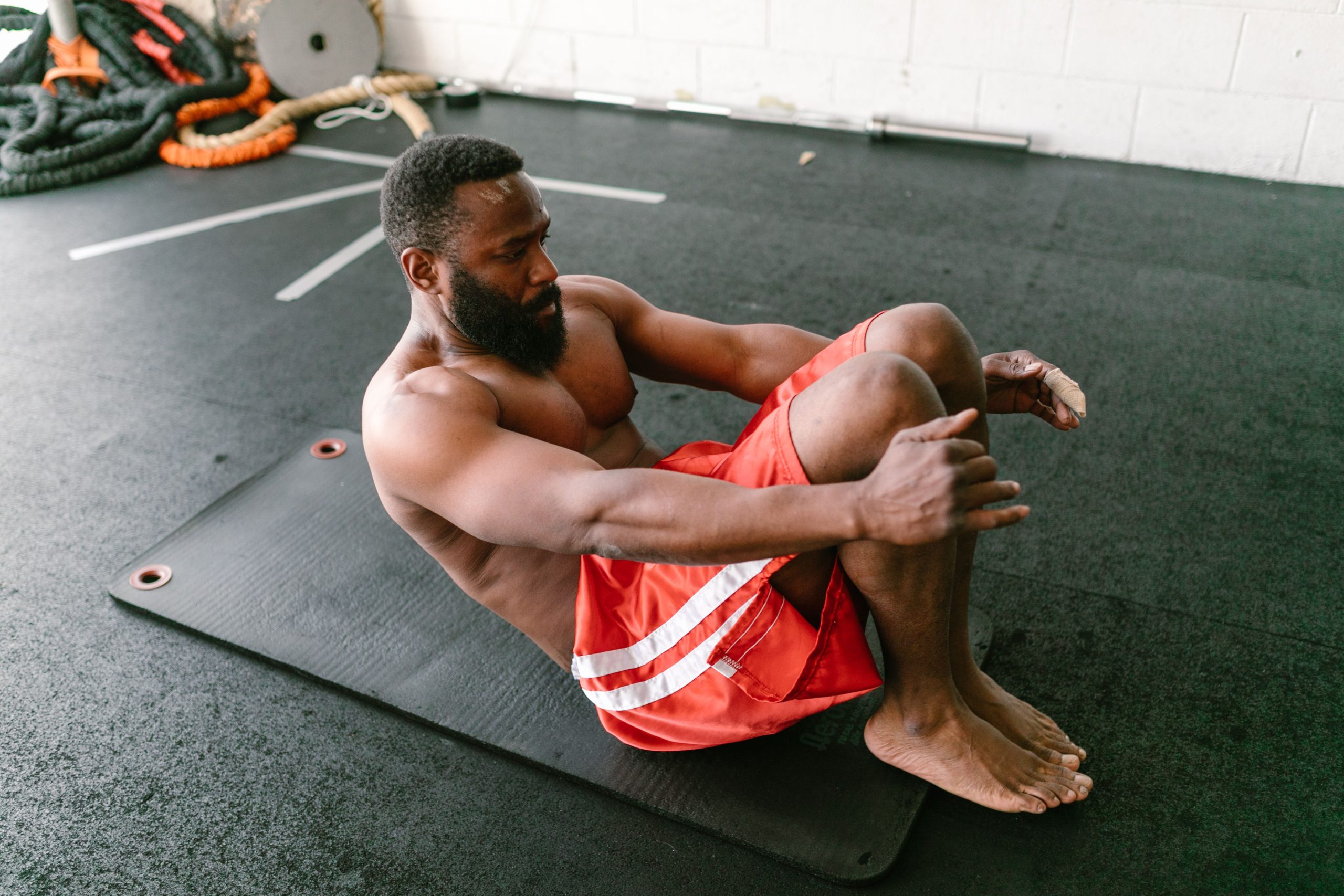 Homme musclé effectuant abdominaux sur tapis