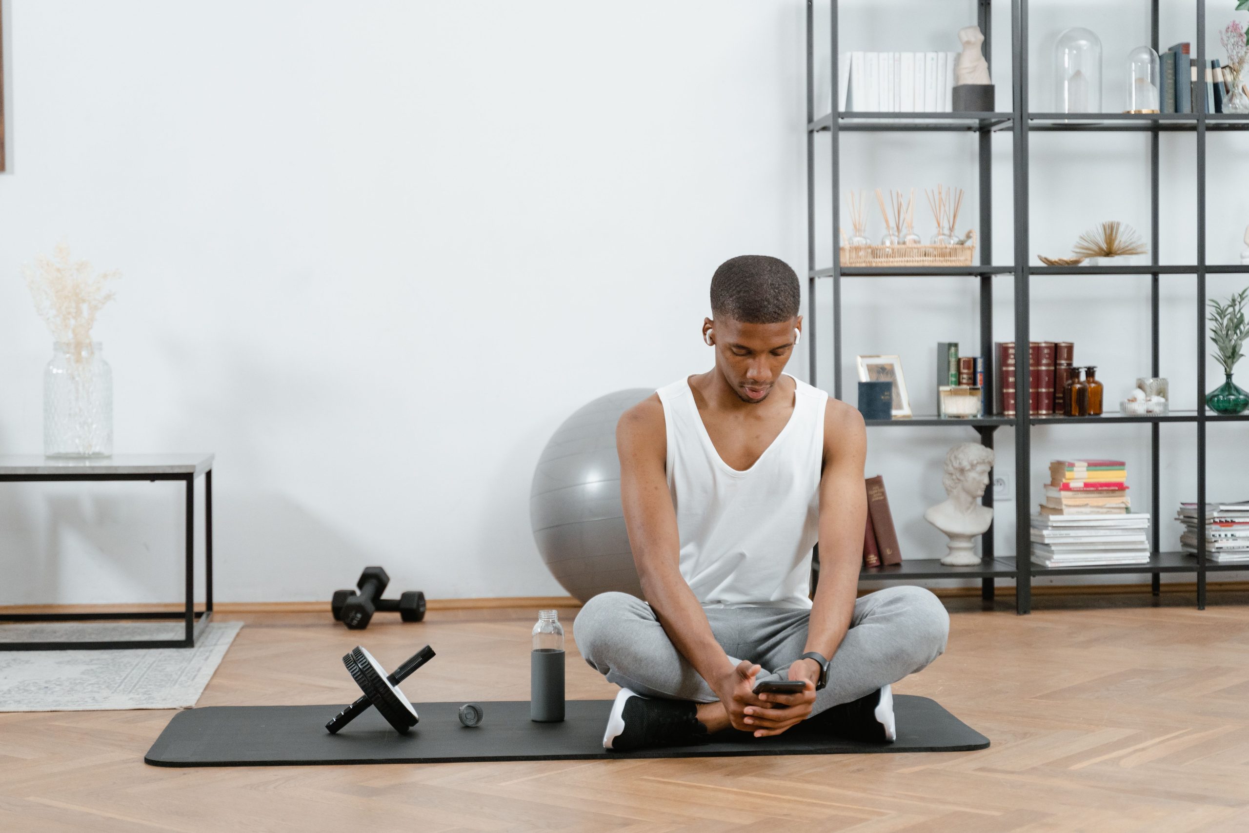 Homme relaxant smartphone après séance entraînement
